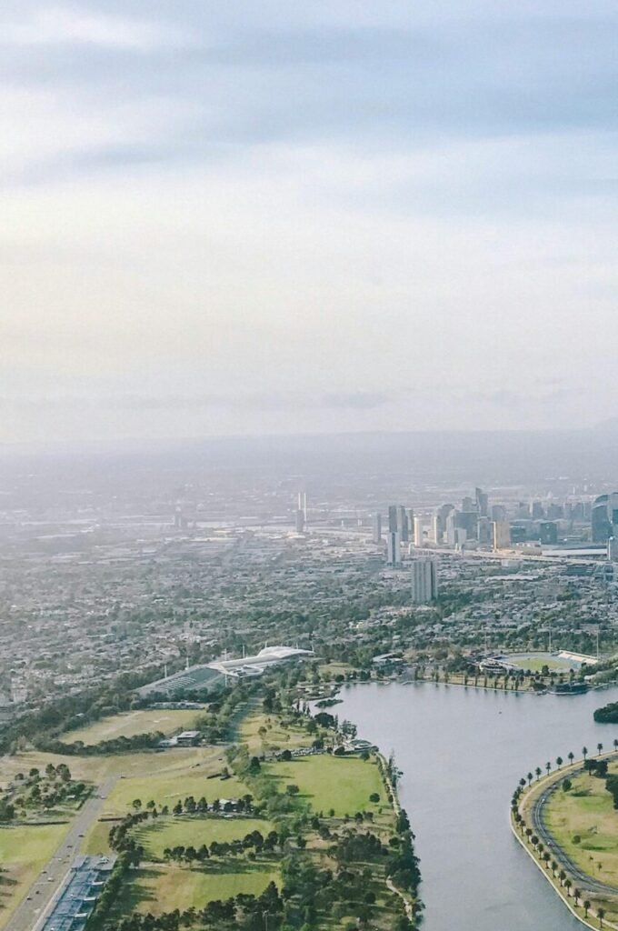 Breathtaking aerial view of Melbourne skyline along the Yarra River with lush greenery.